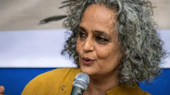 Arundhati Roy speaking into a microphone