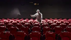 A Worker Sanitizing theater room for safety measure.